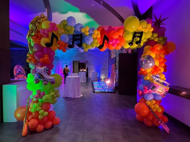 Arco de globos de colores con notas musicales a la entrada