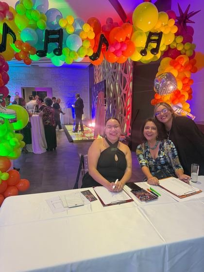 Mesa de registro bajo el arco de globos, recibiendo a los invitados