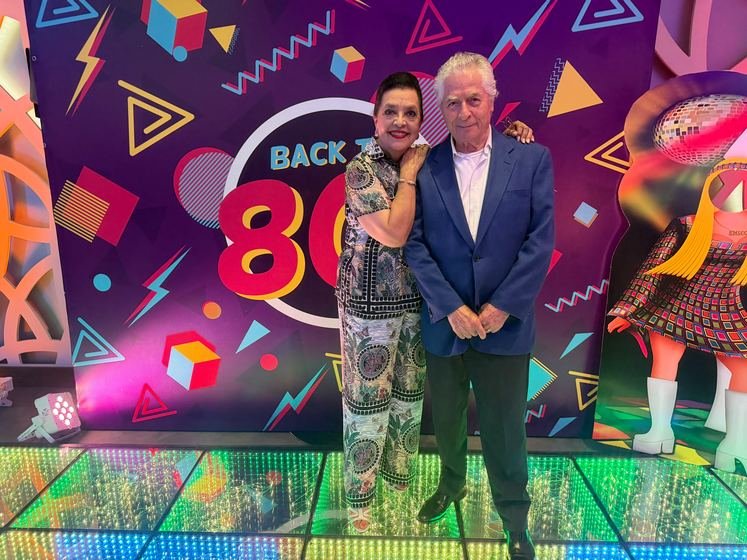 Pareja de invitados en la pista, frente a la mampara ochentera