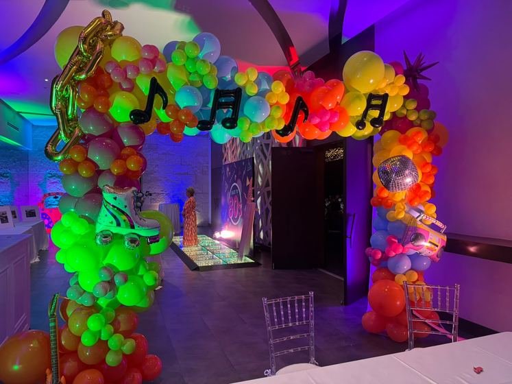 Arco de globos con notas musicales y el salón al fondo