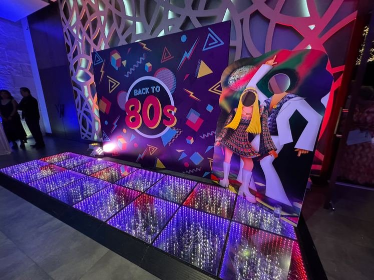 La pista de baile iluminada junto a la mampara retro