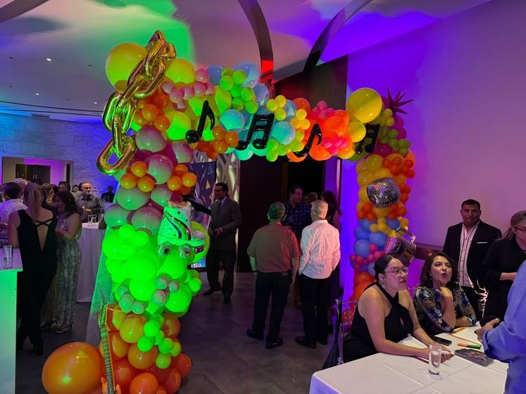 Invitados llegando al registro, junto al arco de globos