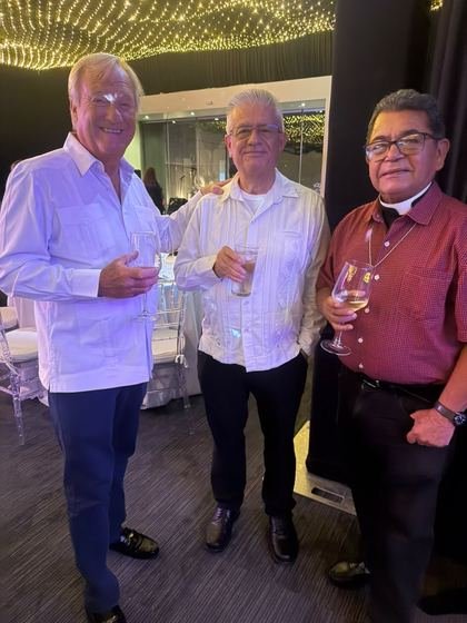 Tres invitados conversando con una copa en la mano