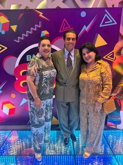 Tres invitados posando frente a la mampara retro